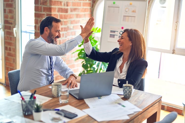 Man and woman working on project high-fiving